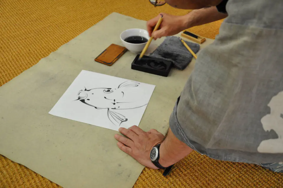 Artisan japonais peignant à l’encre