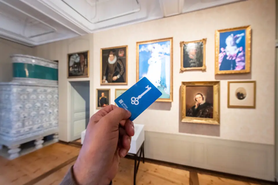 Visiteur utilisant une carte interactive devant des portraits
