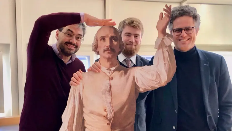 Trois membres de l’équipe posent avec la silhouette de Davel à l’échelle 1:1