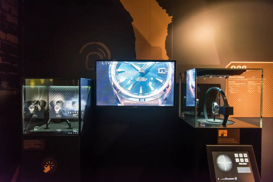 A James Bond watch displayed in front of a screen