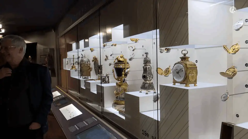 Visitor in front of a display case of table clocks