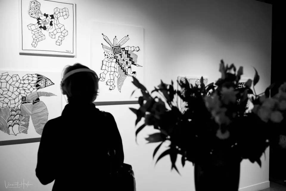 Silhouette d’une visiteuse face aux œuvres graphiques