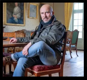 Vincent Jaton assis dans un salon du Château de La Sarraz